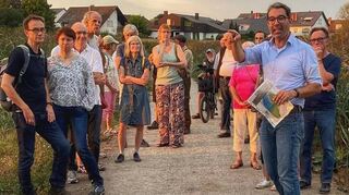 Dr. Andre Baumann im Austausch mit Teilnehmern seiner Exkursion durch die Land-schaft der Schwetzinger Wiesen.