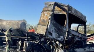 Der Lkw ist vollkommen ausgebrannt. Die Feuerwehr ist am Werk.