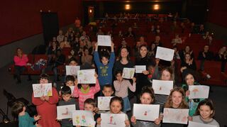 Beim Besuch von Autorin Arta Ramadanis (M., daneben Moderatorin Janine Marielle Ruch) bei Sunday Movies im Februar 2019 wurde diese von den Kindern überrascht, die die Hauptfigur in „Die Reise zum ersten Kuss“ gemalt hatten.