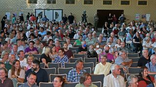 Die Besucher in der Roland-Seidel-Halle warten gespannt auf den Beginn der Bürgermeister-Kandidatenvorstellung, bei der sich Jens Geiß und Pascal Seidel um jeweilige Sympathiepunkte bemühen.