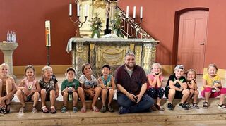 Gemeindediakon Jascha Richter öffnet für die Kinder die Türen des Kirchengebäudes.