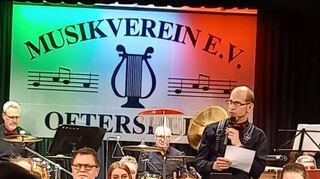 Kein Lautsprecher, sondern ein reflektierter Zeitgenosse: Thorsten Koloska am Mikrofon – umgeben von seinem Orchester.