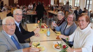 Werner Schellenberg (l.) und Ehefrau Renate (gegenüber) stoßen mit ihren Freunden an und freuen sich über Geselligkeit und Gemütlichkeit auf dem Gemeindefest.