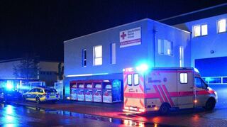 Polizei- und DRK-Einsatzfahrzeuge vor der Rettungswache, auf deren Dach die vom DRK betriebene Unterkunft für wohnungslose Menschen untergebracht ist.