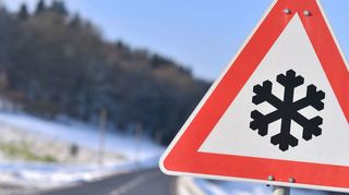 Dieses Warnschild weist auf einer Straße auf Straßenglätte hin.