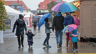 Regenschirme und Gummistiefel sind am Sonntag bei den wenigen Besuchern auf dem Kerweplatz angesagt – doch gerade bei den Jüngsten überwiegt trotzdem die Freude über das Fest.