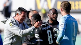 Alois Schwartz (v. l.), Cheftrainer des SV Sandhausen, herzt den Torschützen des Tages Christian Kinsombi – David Kinsombi und Keeper Patrick Drewes reihen sich in die Gruppe der Gratulanten nach dem ersehnten Erfolg mit ein.