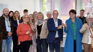 OB Dr. René Pöltl (M.), einige Verwaltungsmitarbeiter und Jochen Wiegand (hinten) vom Partnerschaftsverein stoßen mit Bürgermeisterin Cathérine Paillard (blauer Mantel) und den französischen Gästen auf die Freundschaft an.