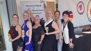 Dreimal mit Pokal: Trainerin Sabine Backfisch (r.) und ihre erfolgreichen Tänzerinnen, die für tolle Platzierungen in Stuttgart gesorgt haben.