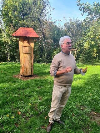 Dr. Ulrich Finkenzeller spricht über Wildbienenhotels, wie es im Wasserturm im Hintergrund eines gibt.