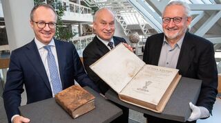 Oliver Kolb (v. l.), Konrad Reichert (Sparkassenstiftung) und Dr. Armin Schlechter (Leiter Sammlungen Landesbibliothekszentrum) mit den restaurierten Büchern.