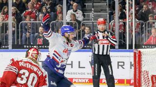 Torschütze Matt Donovan reißt nach dem Tor zum 2:1 für die Adler die Arme jubelnd nach oben. Haie-Torhüter Mirko Pantkowski bleibt nur das Nachsehen, der Puck ist im Kasten.