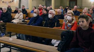 In den Kirchenbänken hören die Menschen von erschütternden Schicksalen.
