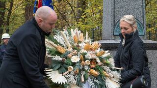 Bürgermeister Pascal Seidel (l.) und Anja Drake vom Friedhofsamt legen während des Volkstrauertages auf dem Friedhof einen Kranz nieder.