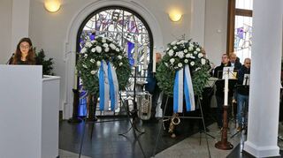 Hebel-Schülerin Charlotte Conrad (l.) spricht bei der Gedenkfeier neben den Kränzen in der Schwetzinger Friedhofskapelle.