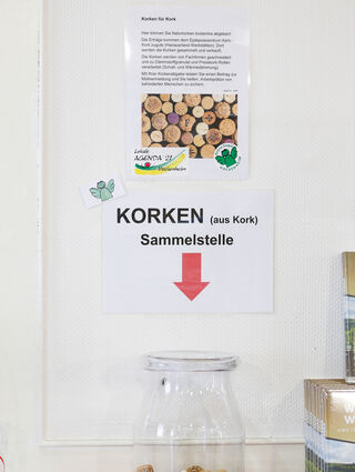 Ein Schild erklärt, wies geht. Wichtig dabei ist, dass nur Korken aus Kork in die Sammelbehälter gelangen.