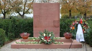 Am Ehrenmal für die Opfer des Zweiten Weltkrieges legen Bürgermeister Nils Drescher und Diakon Michael Barth-Rabbel anlässlich des Volkstrauertages einen Gedenkkranz nieder.