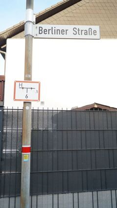 Laternenring in Rot-Weiß und der Barcode-Aufkleber in Gelb sind hier in der Berliner Straße angebracht.