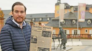 CDU-Landtagsabgeordneter Andreas Sturm hält den Beweis schwarz auf weiß in die Kamera auf dem Schlossplatz. In dieser Badischen Chronik ist bereits vom Rokokotheater die Rede – das ist also keine Erfindung der Nazis.
