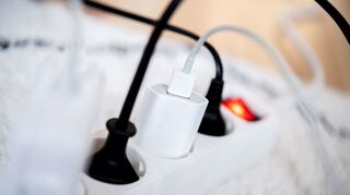 Die Netzstecker mehrerer Elektrogeräte stecken in einer Steckdosenleiste in einem Wohnzimmer. Viele Stromversorger erhöhen die Preise ab Januar 2023. (Symbolbild)