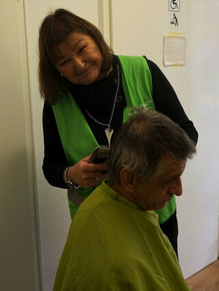 Friseurin Michaela schneidet ihrem Kunden Dieter kostenlos die Haare.