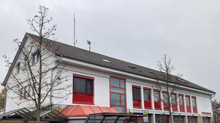Oben auf dem Dach neben der Funkantenne stehen die neuen Sirenen (Bildmitte) auf der Spitze des Feuerwehrgerätehauses.