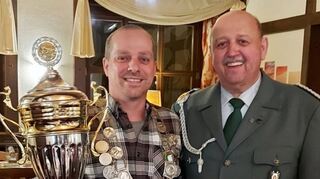 Mit Königskette und großem Pokal präsentiert sich der SG-Schützenkönig Philp Higel zusammen mit mit Oberschützenmeister Ulrich Fitterer seinen Untertanen beim Hubertusball.