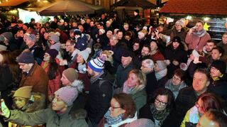 Dicht an dicht stehen die Menschen bei der offiziellen Eröffnung des Adventsmarktes vor der Bühne, niemand will sich die Auftritte der Kinder und des Posaunenchors entgehen lassen.