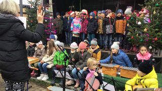 Chor und Schulorchester der Lußhardtschule mit Lehrerin Annette Schrepp beim Auftritt auf dem Weihnachtsmarkt. Bild: Hettwer