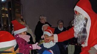 Der Nikolaus verteilt Geschenke: Die Kinder nehmen sie bei der Feier des Asylkreises im Gemeindepark dankbar entgegen.