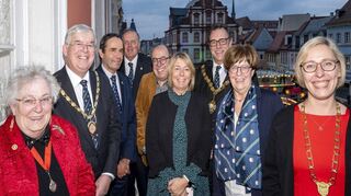 Speyer hat eine neue englische Partnerstadt. Hier sind die Stadtspitzen von Chichester nach dem Festakt im Historischen Ratssaal zur Besiegelung der Städtepartnerschaft auf dem Balkon zu sehen. Im Hintergrund die Alte Münz und der Weihnachtsmarkt: Town Clerk Rodney Duggua (2. v.l.), Fachbereichsleiter Dr. Matthias Nowack (5. v.l.), Mayor Julian Joy (3.v.r.), Bürgermeisterin Monika Kabs und Oberbürgermeisterin Stefanie Seiler gelten als Schrittmacher der neuen Verbindung.