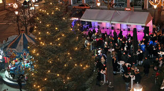 Der Plankstadter Weihnachtsmarkt: Unter dem großen Tannenbaum stehen ein Kinderkarussell (l.), eine Bühne und fünf Marktstände.