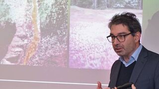 Dr. Andre Baumann vor Aufnahmen des Hardtwaldes, die bei dem Vortrag besprochen wurden.