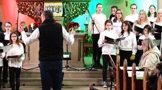 Vor dem bunt erleuchteten Altarraum der Schutzengelkirche präsentieren Schüler des Schwetzinger Hebel-Gymnasiums ihr musikalisches Können und stimmen die Brühler Senioren auf die Weihnachtszeit ein.