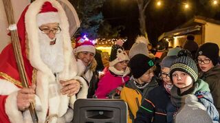 Auch wenn sie etwas warten müssen, freuen sich die Kinder über den Besuch eines ganz besonderen Ehrengastes bei der Siedlerweihnacht.