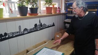 Rolf Bartling steht in seinem Arbeitsraum und präsentiert Werke, die kürzlich entstanden sind und solche, an denen er tätig ist.
