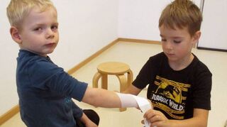 Konzentriert üben die Kinder im „Haus der kleinen Hasen“ wie man einen Verband richtig anlegt.