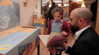Das bis vor kurzem gastierende Geschichtslabor des Lernorts Kislau: Karla (5 Jahre) und Matthias Agirdogan schauen zusammen eins der Arbeitshefte durch.
