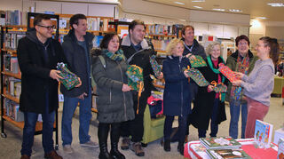 In Stofftaschen verpackte Bücher als Jubiläumsgeschenk: Dr. Markus Hartmann (v. l.), Hanspeter Rausch, Silvia und Alexander Mansel, Ingeborg Bamberg, Winfried Vaudlet, Monika Schroth und Renate Hettwer erfreuen Laura Wanisch.