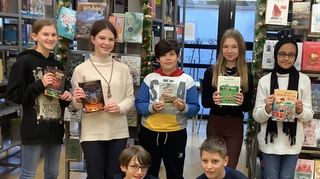 Die Klassensieger lesen aus ihren Lieblingsbüchern vor – hinten v. l.: Lisa Kasparek, Yana Sklyarenko (Schulsiegerin), Göktan Karakol, Matylda Karzen, Madiha Ahmed; vorne: Philipp Leonardi und Colin De Haan.