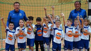 Jeder Spieler erhält einen Pokal: Die F-Jugend des Gastgebers SV 98 Schwetzingen mit den Trainern Christian Wolf (l.) und Benjamin Ehl freut sich über die Belohnung nach dem Jugendturnier zum 125-Jahre-Jubiläum.
