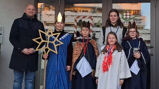 Gruppenfoto: Bürgermeister Pascal Seidel (v. l.) begrüßt die Sternsinger Béla, Emil, Lisa, Annika und Juli vor dem Oftersheimer Rathaus.