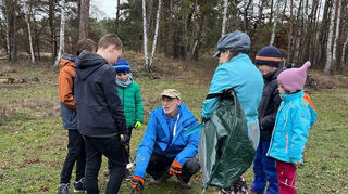 Schwetzingens Nabu-Vorsitzender Professor Dr. Frank Nürnberg erklärt den Kindern, wie die Pflanzen aussehen, die weggepflegt werden sollen, und bereitet sie auf den Einsatz im Hirschackerwald vor.