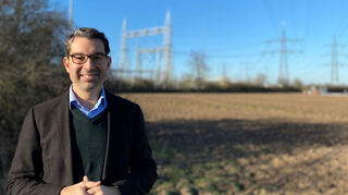Dr. Andre Baumann vor der Bestandsstromtrasse in Altlussheim