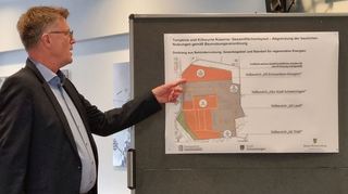 Andreas Jacob; Geschäftsführender Gesellschafter der die FIRU mbH, erklärt anhand der Grafik die Flächenaufteilung bei der Tompkins Barracks. Mit dem Finger deutet er auf den etwa 6,2 Hektar großen Bereich, der für eine Photovoltaik vorgesehen ist.