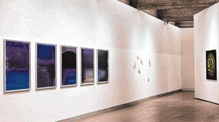 In den Werkserien von Claus Stolz (links und rechts im Bild) scheinen Raum und Zeit keine Begrenzung mehr: Blick in die Ausstellung im Port 25.