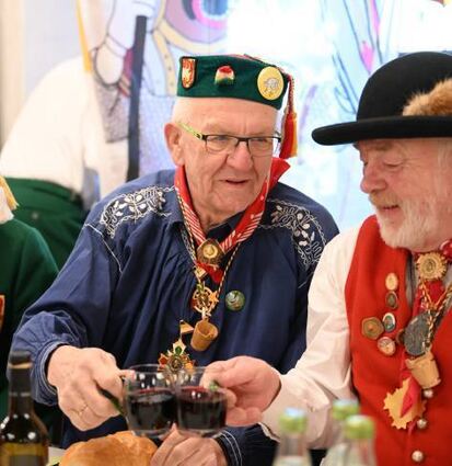Kretschmann stößt in Riedlingen mit seinen Sitznachbarn an.