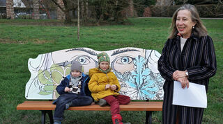 Kulturreferentin Dr. Barbara Gilsdorf stellt die dem in Mannheim geborenen Wissenschaftler Karl Friedrich Schimper gewidmete Themenbank vor. Marlene (7) und Frederic (5) sitzen auf dem Schmuckstück zur Probe.