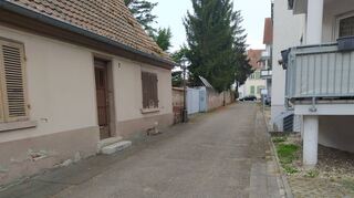 Die Fahrspur im Dietzengässel ist sichtlicht schmal. Da die Gasse zudem von Mauer und Zäunen gesäumt ist und außerdem kein Gehweg vorhanden ist, mangelt es Fußgängern an Ausweichmöglichkeiten.