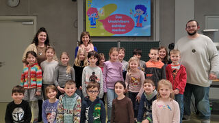 Schüler der Klasse 1a freuen sich zusammen mit Projektleiterin Carolyn von Korff (hinten links), Klassenlehrerin Kirsten Schebek (hinten mitte) und dem wissensch.Volontär Daniel Reinemuth